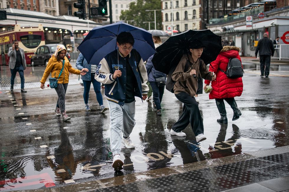 People walk through the rain and wet weather