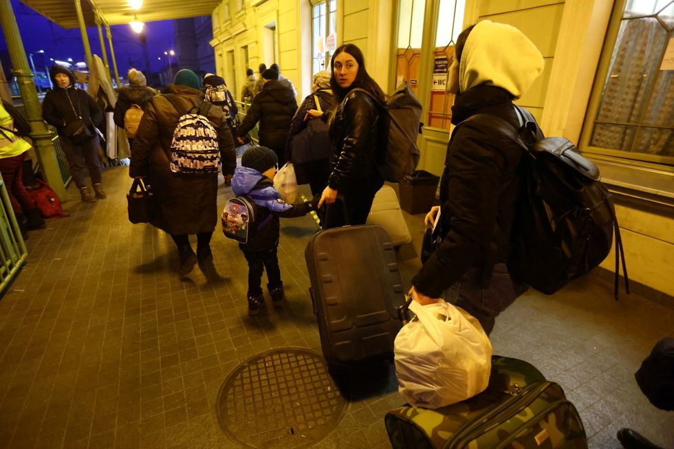 People walk to a platform of the railway station for onward transport by train to Krakow, after fleeing the Russian invasion of Ukraine, in Przemysl, Poland, March 8, 2022. REUTERS/Fabrizio Bensch