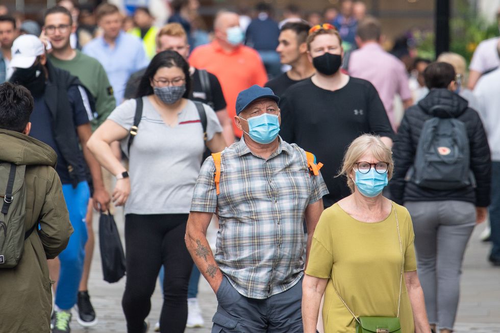 People wearing face masks among crowds of pedestrians in Covent Garden, London.