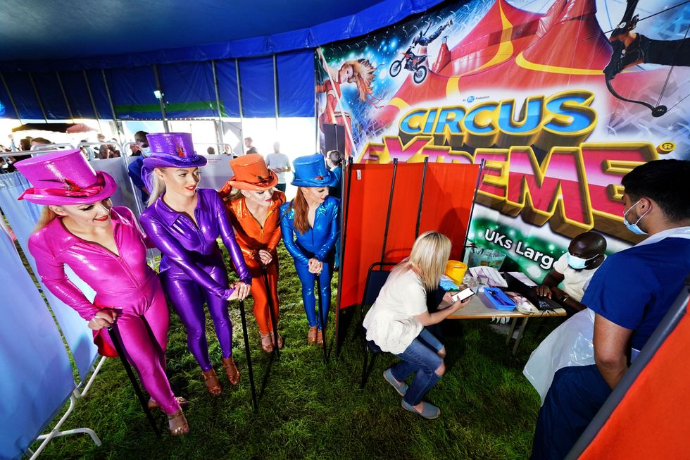 Performers from Circus Extreme watch as Rhiannon Alexander, 34 from Bradford, waits to have a Covid-19 vaccination at a pop-up vaccination clinic in the marquee of the circus in Halifax.