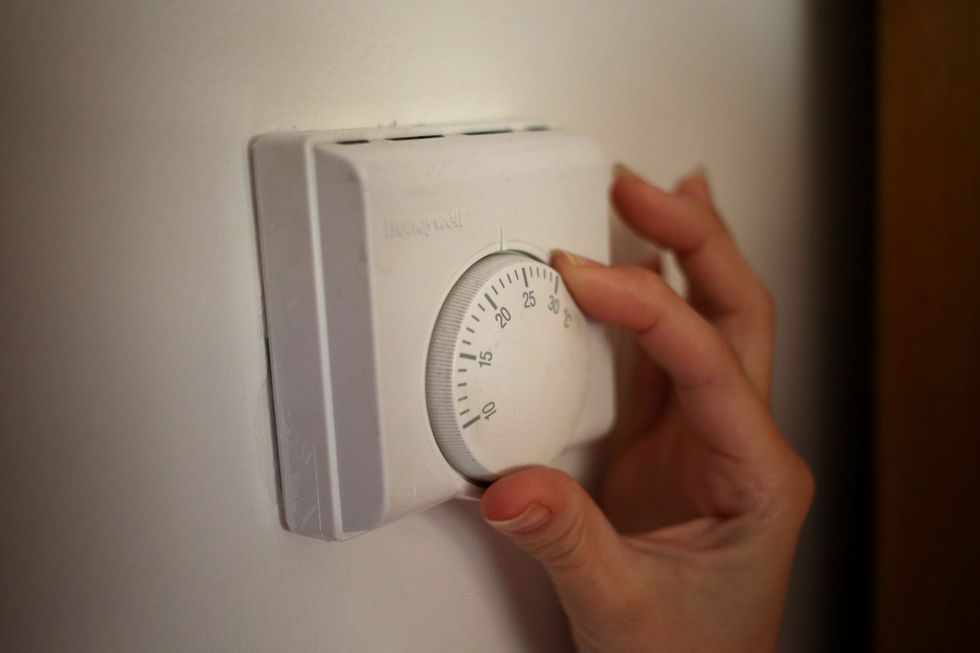 Person adjusts thermostat