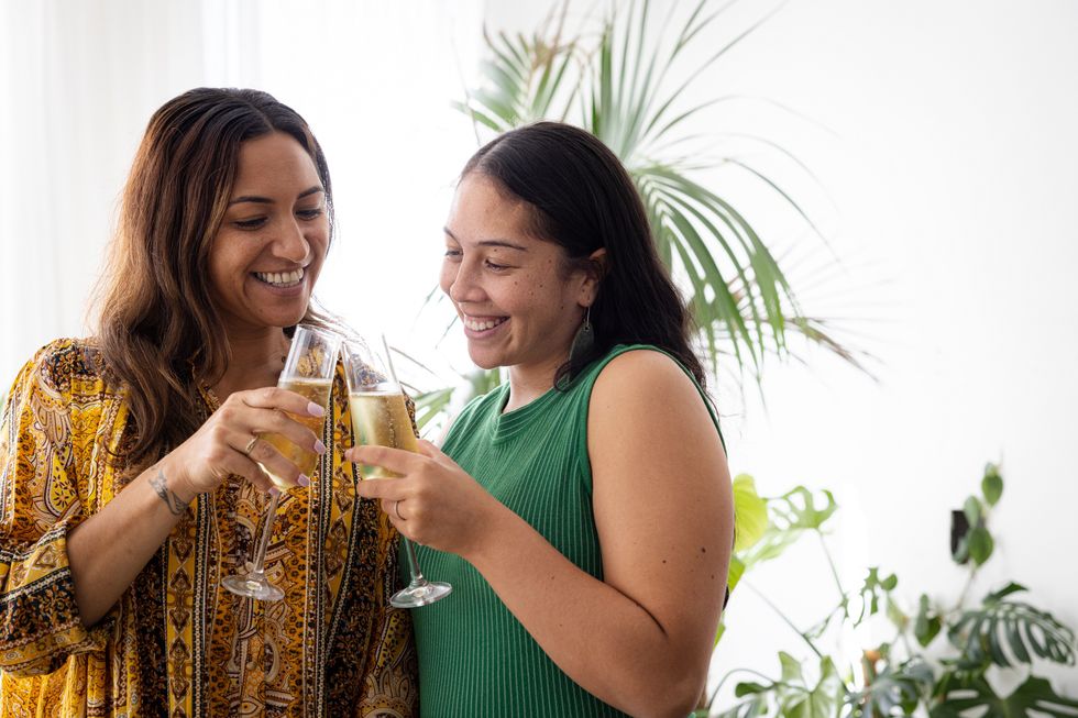 Person celebrating with glasses of bubbly