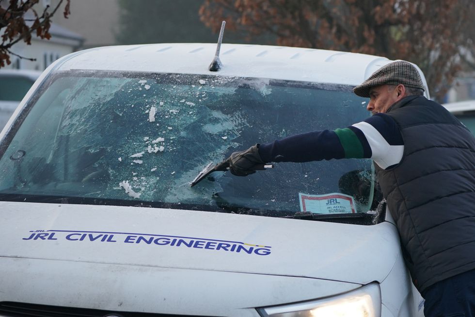 Person clearing windscreen frost