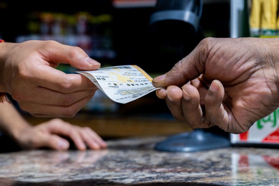 Person handing over lottery ticket