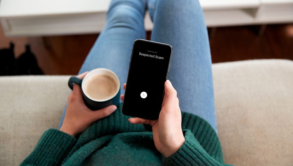 Uma pessoa que tem um telefone celular e suspeita de uma ligação fraudulenta