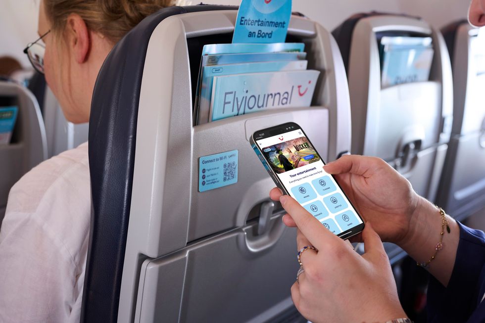 Person holding phone on TUI flight
