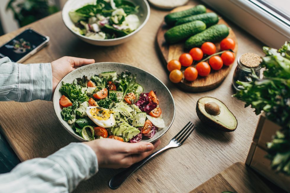 PERSON HOLDING PLATE OF SALAD