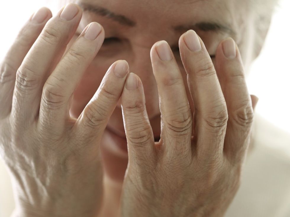 Person holding their hands over their face