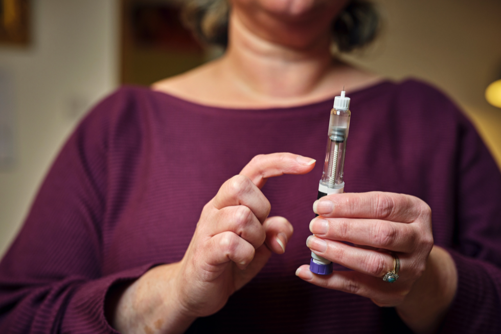 Person holding weight loss jab