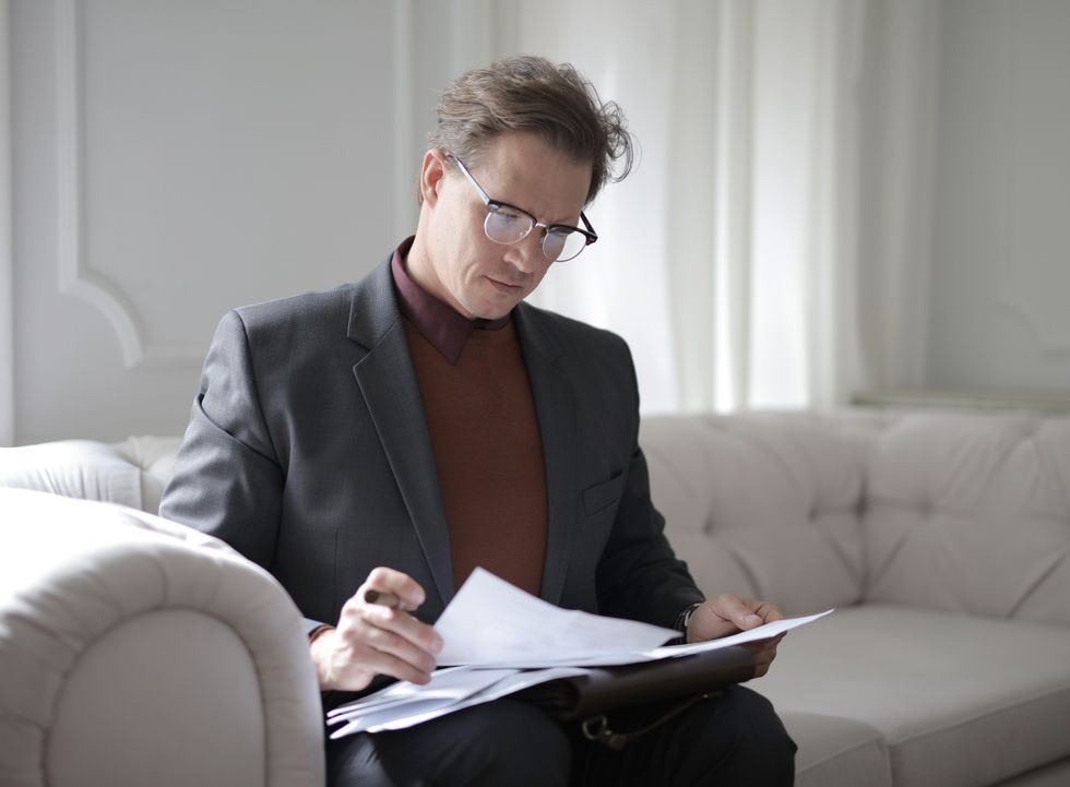Person looking at documents while sitting on sofa