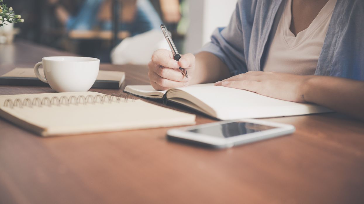 Person looking at notebook and phone
