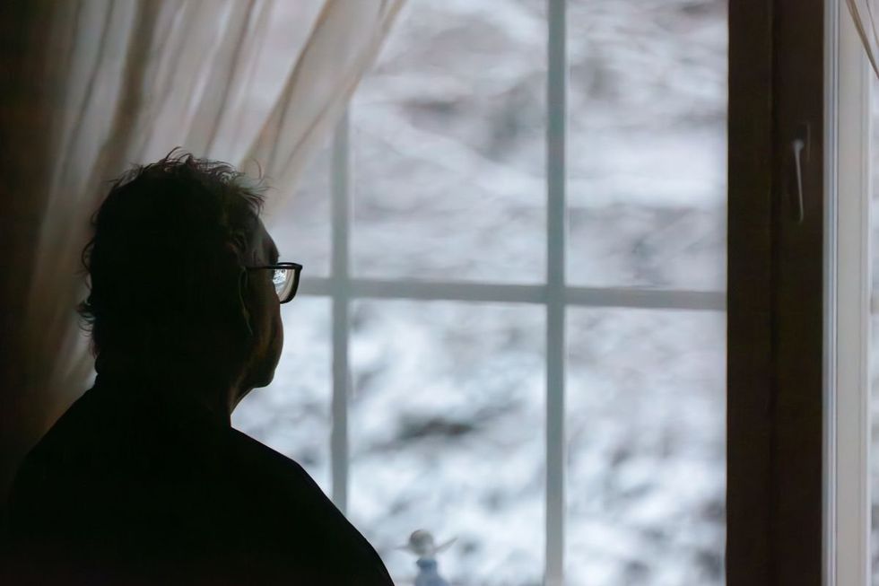 PERSON LOOKING OUT WINDOW