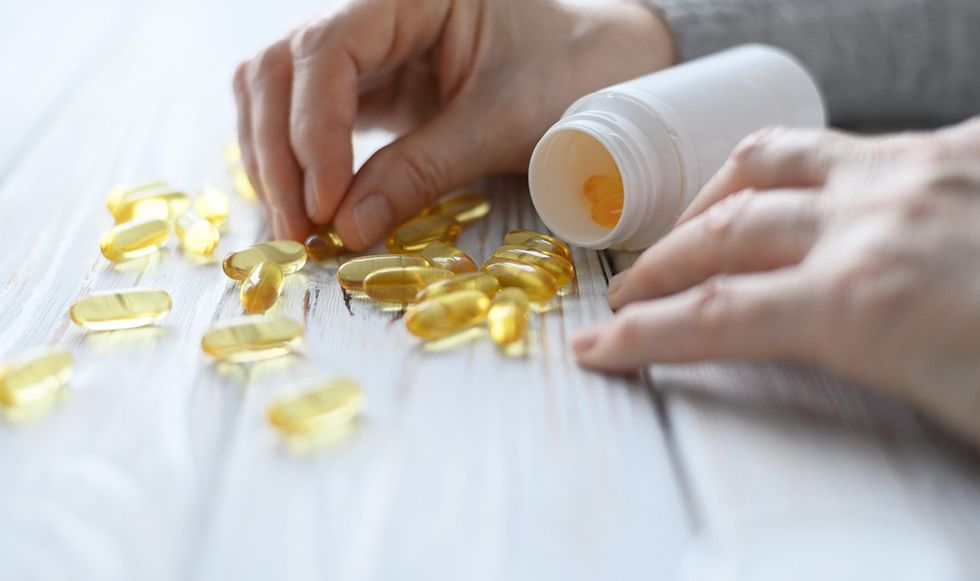 Person looking through scattered vitamin d supplements