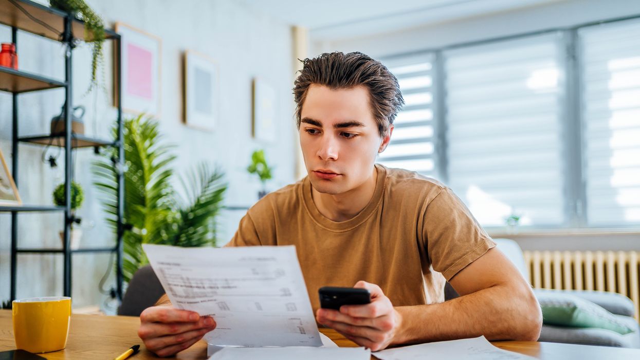 Person looks at calculator and document