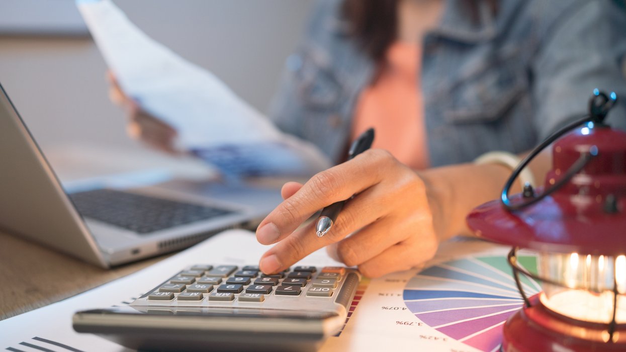 Person looks at calculator while working out budget