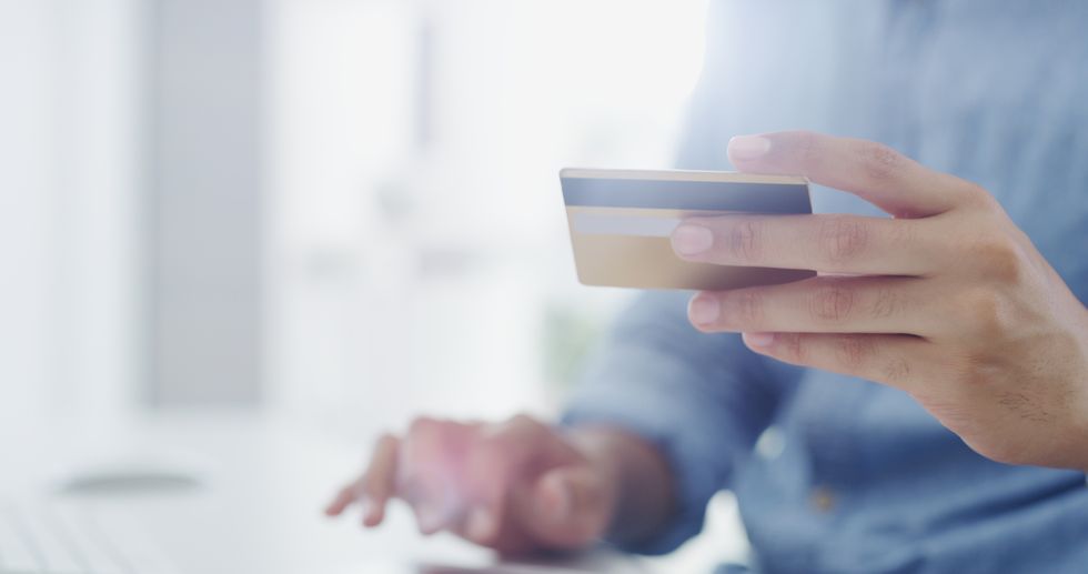 Person looks at debit card while using computer