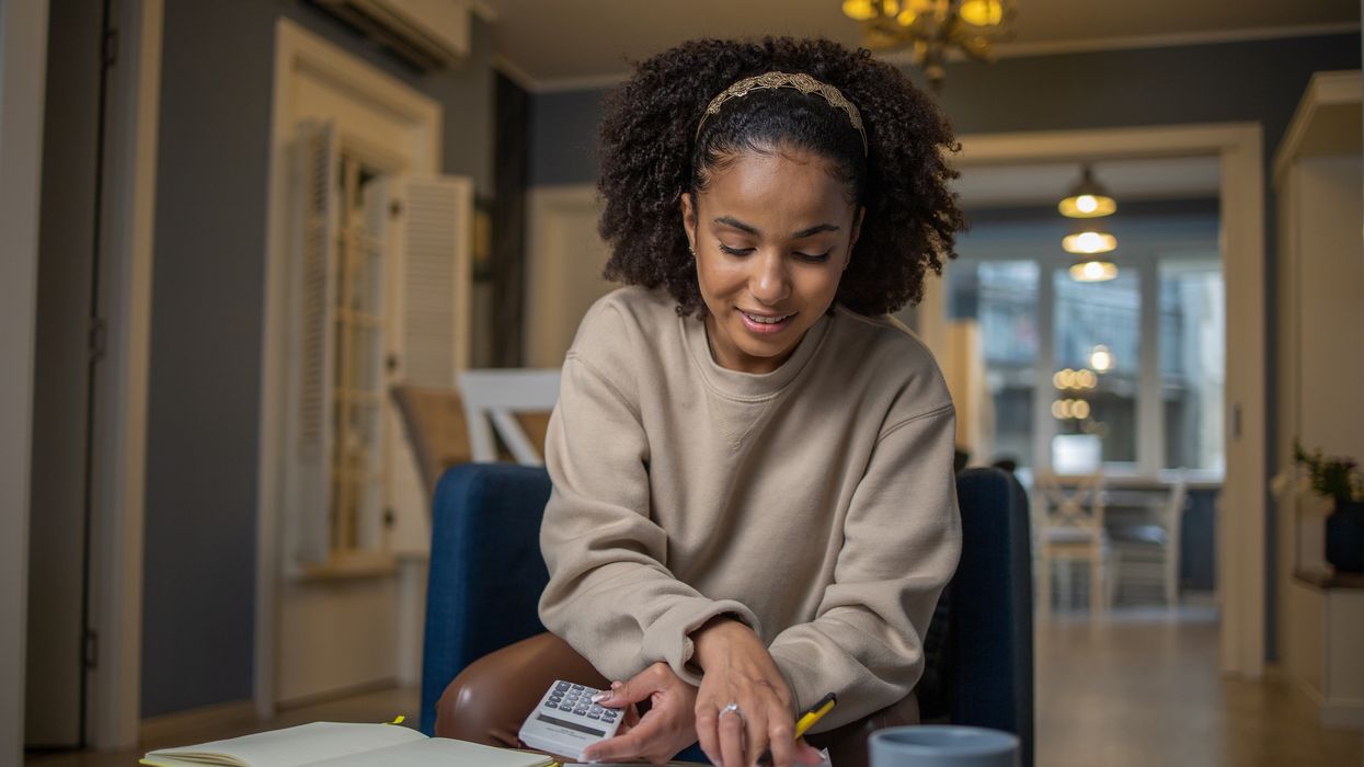 Person looks at documents and calculator