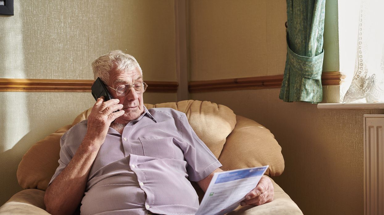 Person looks at energy bill while on the phone