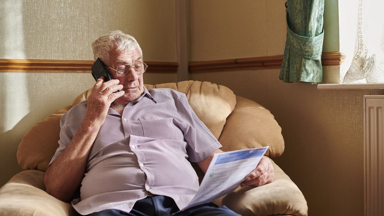 Person looks at energy bill while on the phone