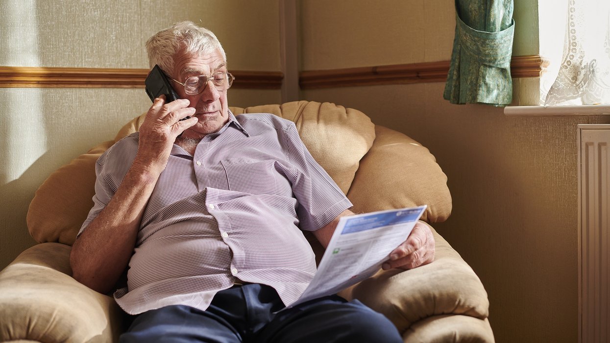 Person looks at energy bill while on the phone
