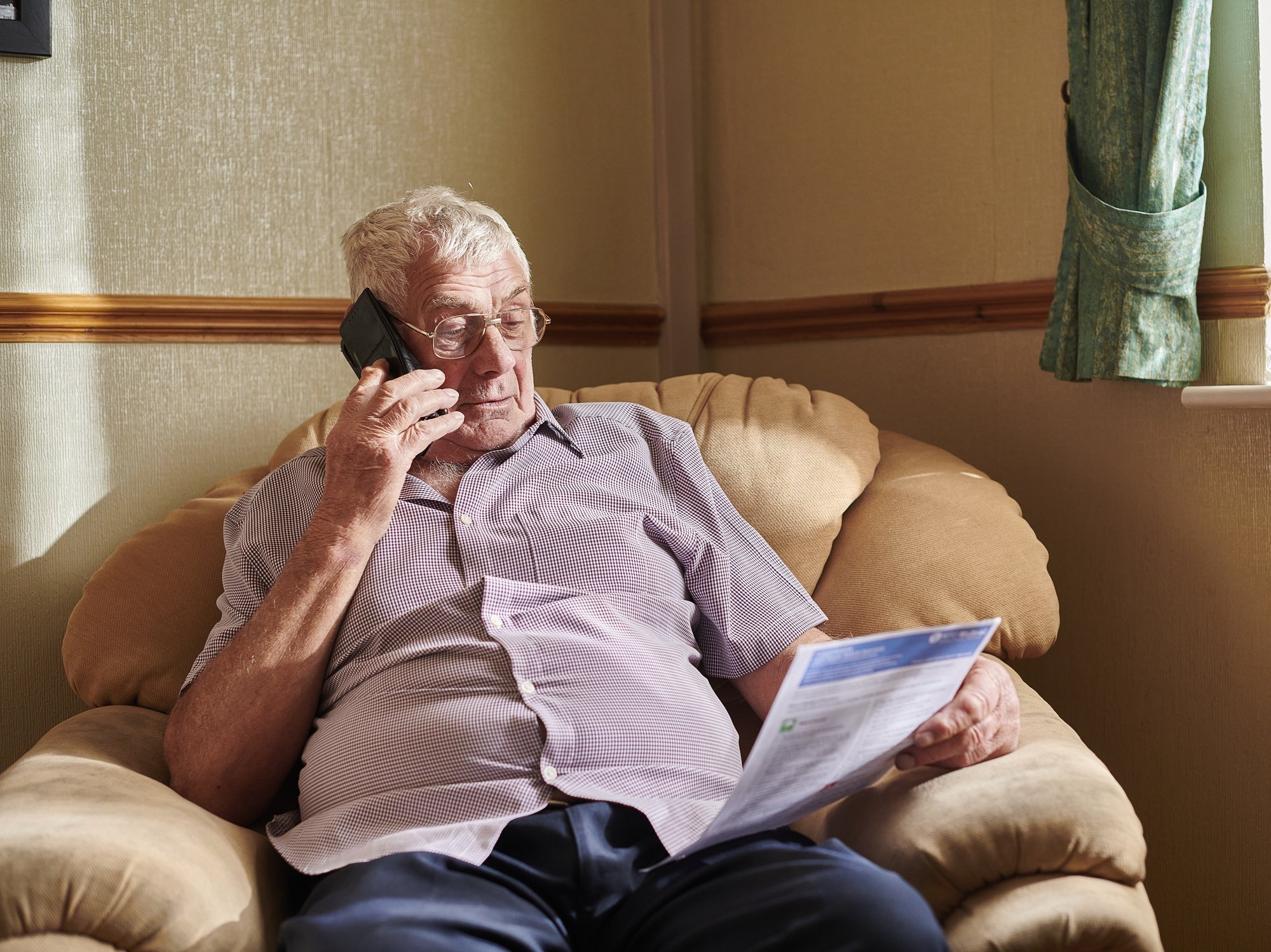 Person looks at energy bill while on the phone