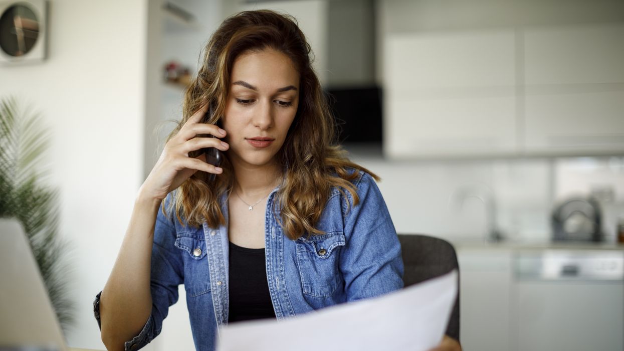 Person looks at energy bills statement while on phone