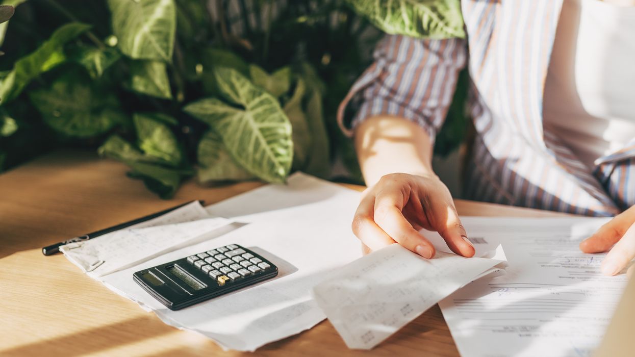 Person looks at finances beside calculator