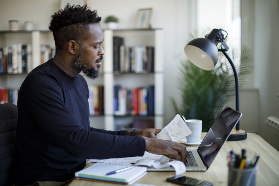 Person looks at letter beside laptop