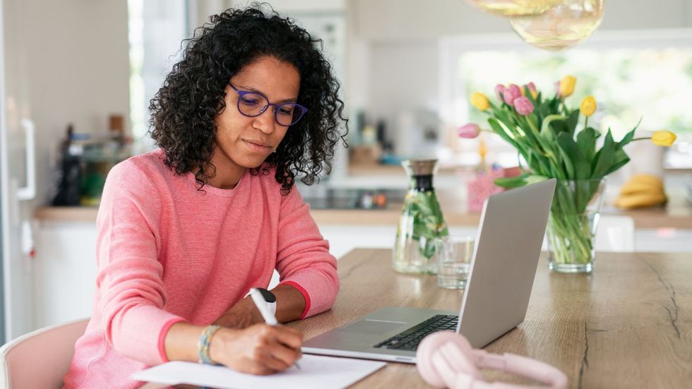 Person looks at paper while holding pen