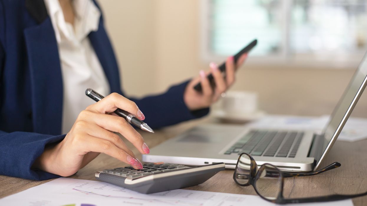 Person looks at phone and laptop