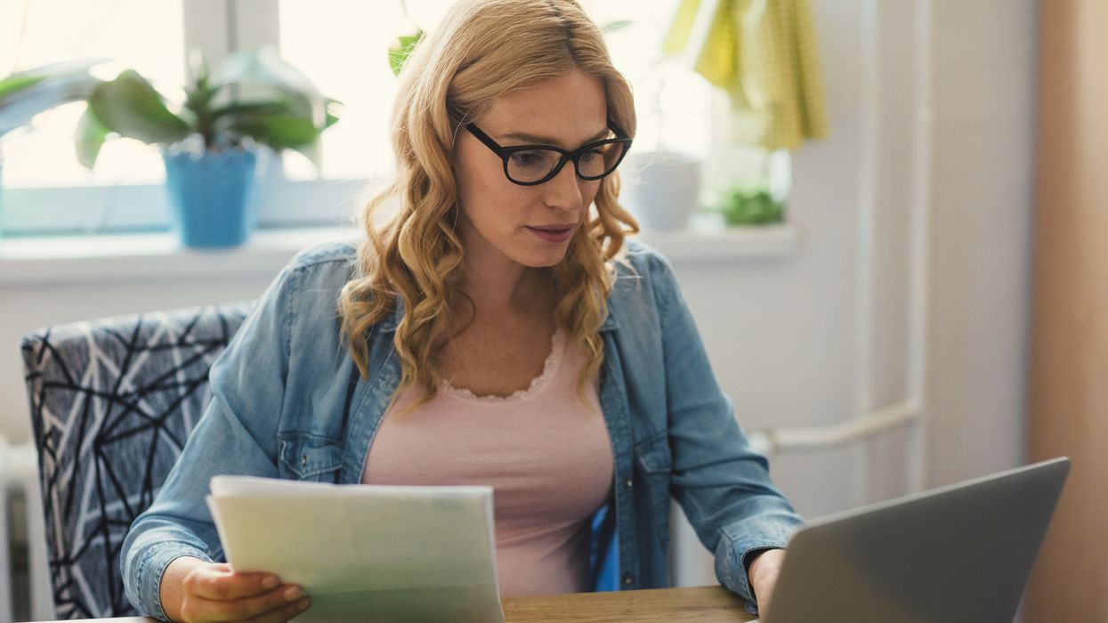 Person looks at water bill statement and laptop