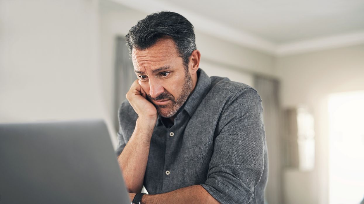 Person looks worried at laptop