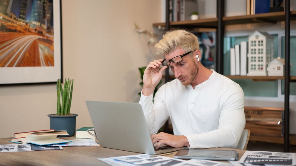 Person looks worried at laptop