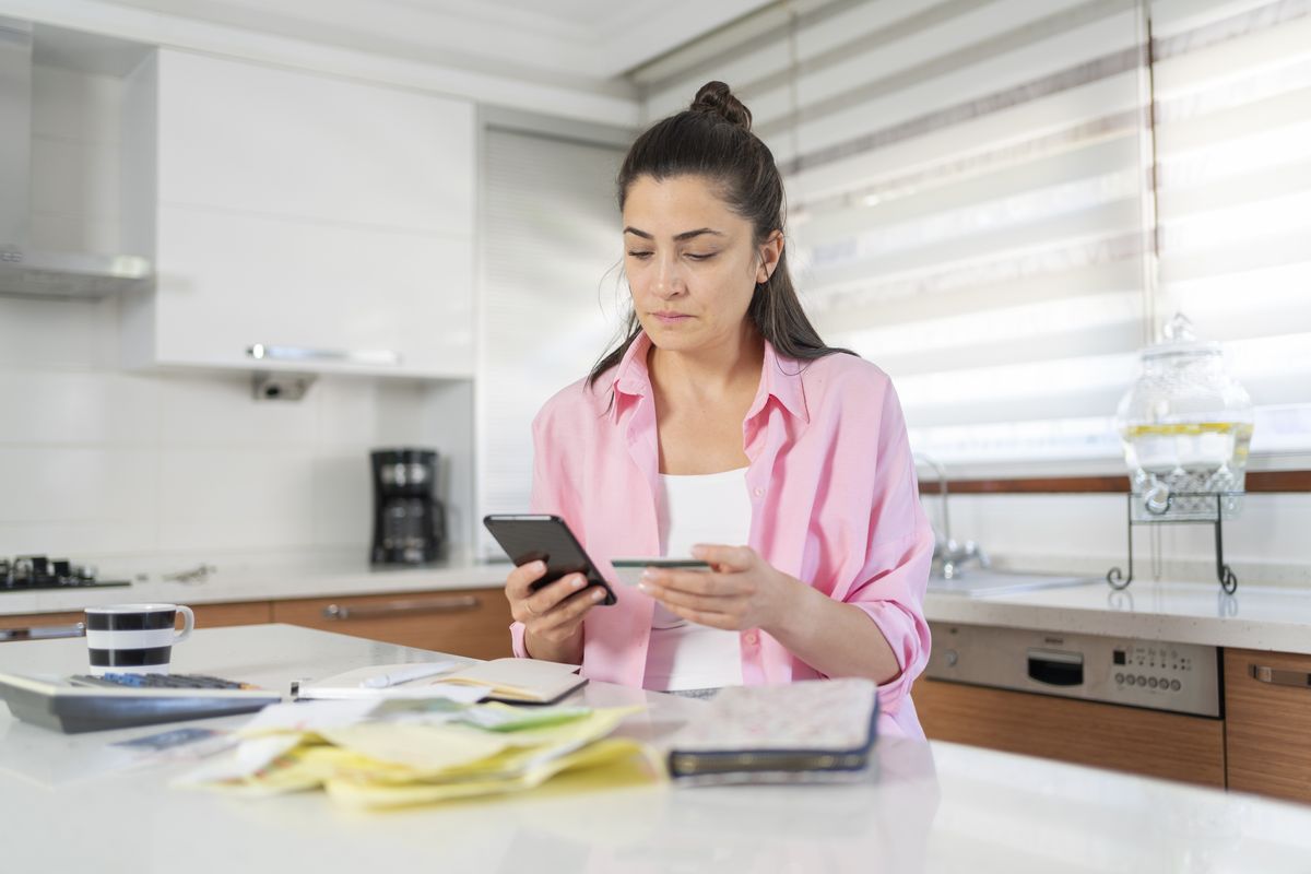 Person looks worried at phone in kitchen