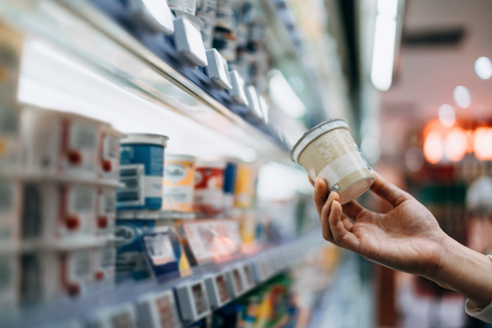 Person picking out a yoghurt in a supermarket
