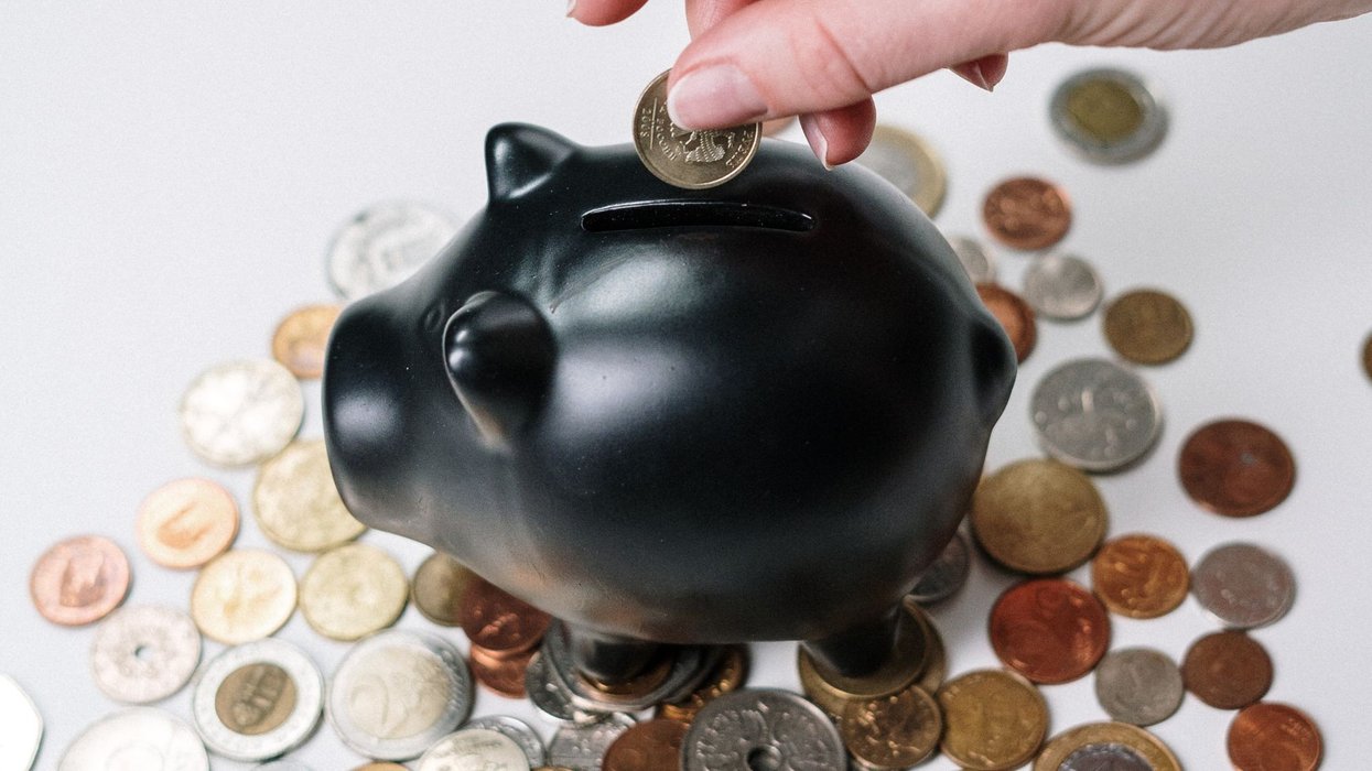 Person putting money in a piggy bank
