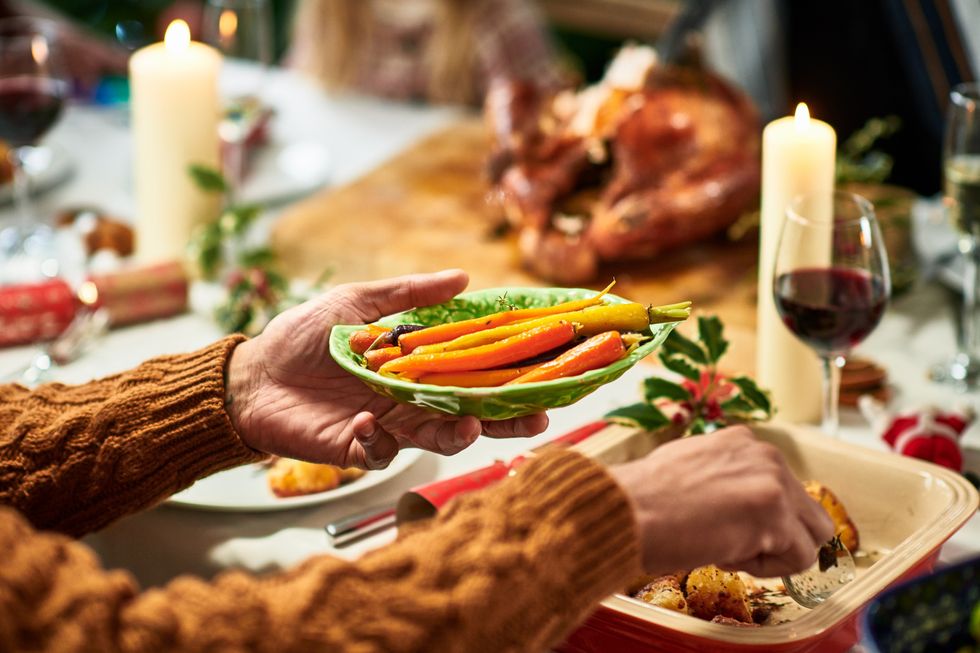 Person serving vegetables during Christmas dinner