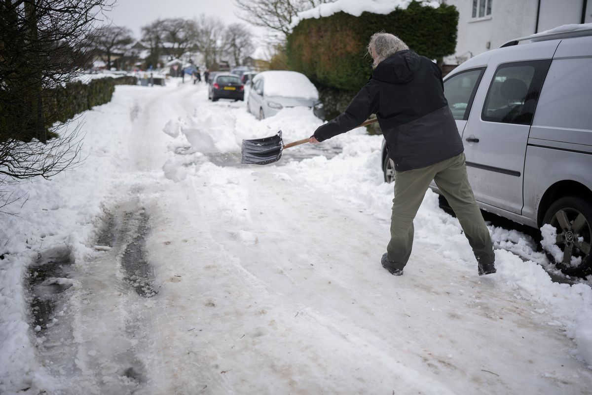Person shovels snow in Cumbria