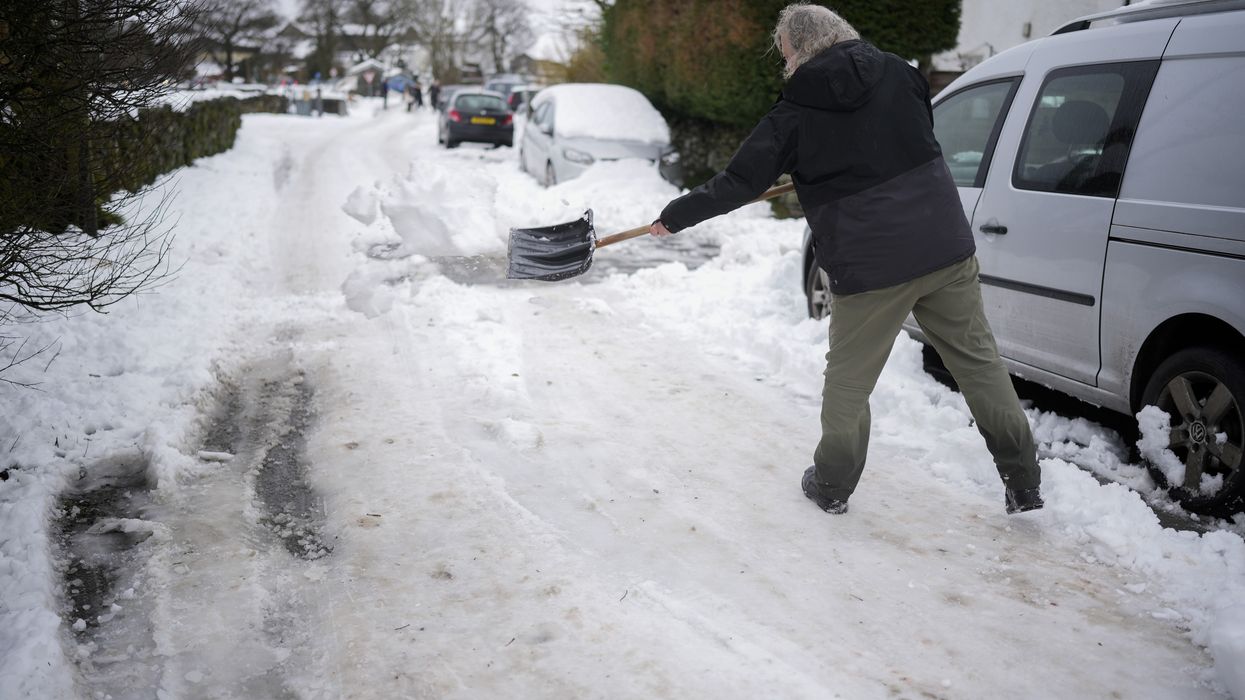 Person shovels snow in Cumbria