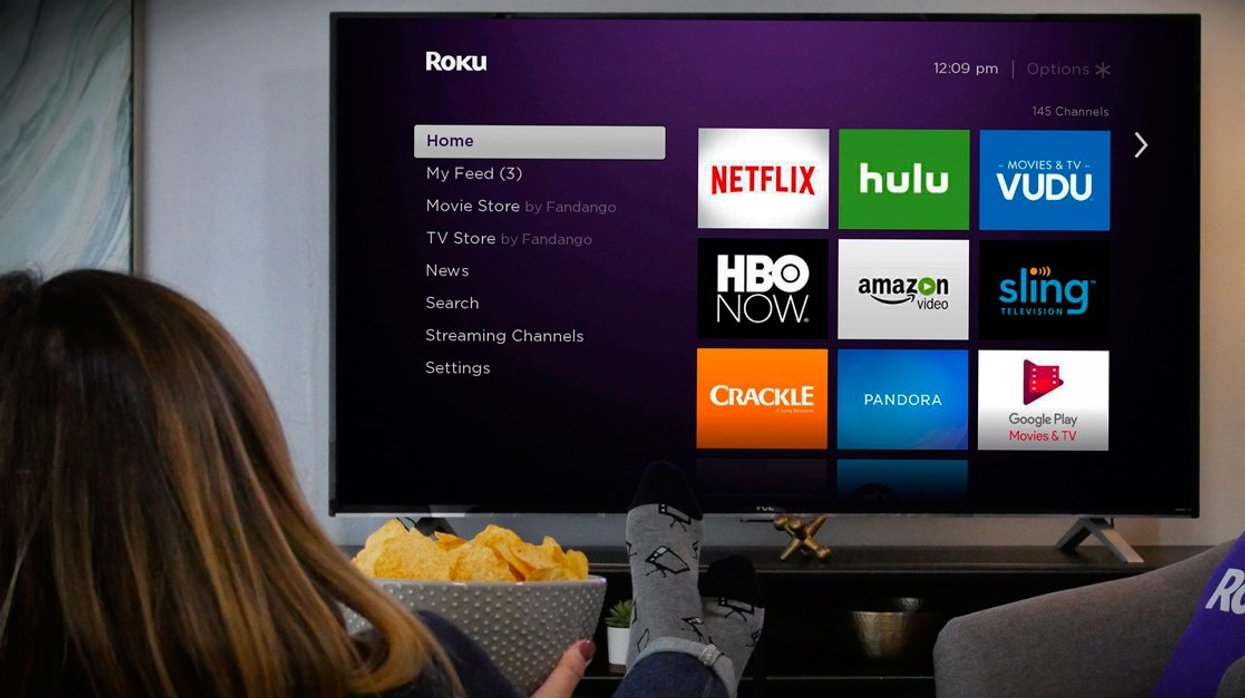 Person sitting in front of Roku TV