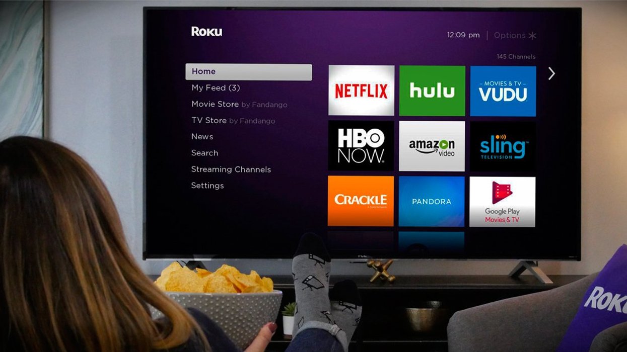 Person sitting in front of Roku TV