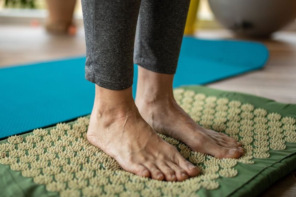 Person standing on acupressure mat