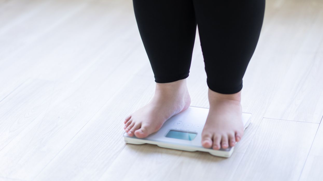 PERSON STANDING ON SCALES
