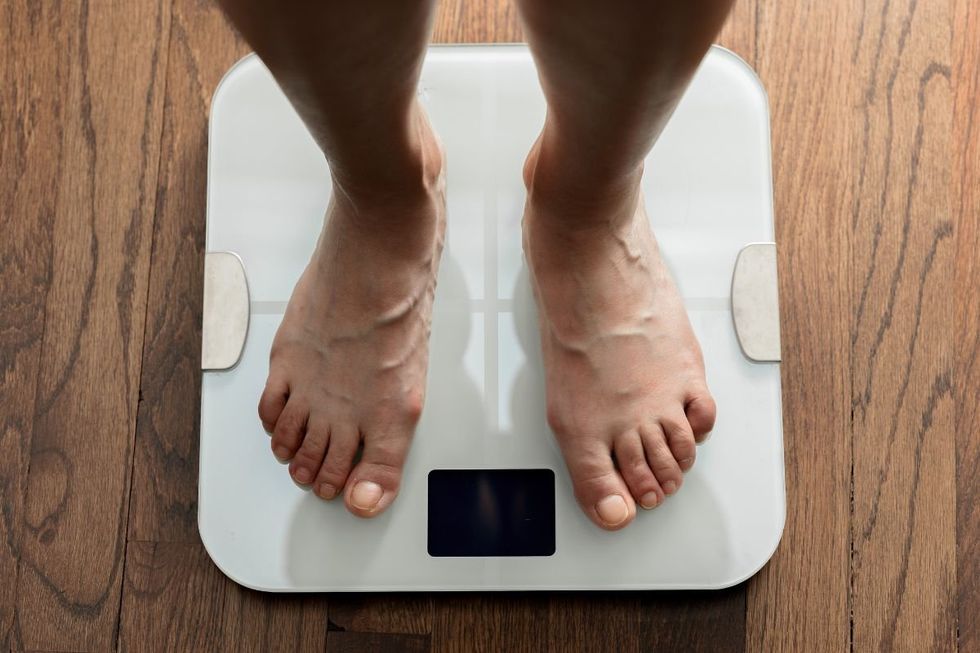 PERSON STANDING ON SCALES