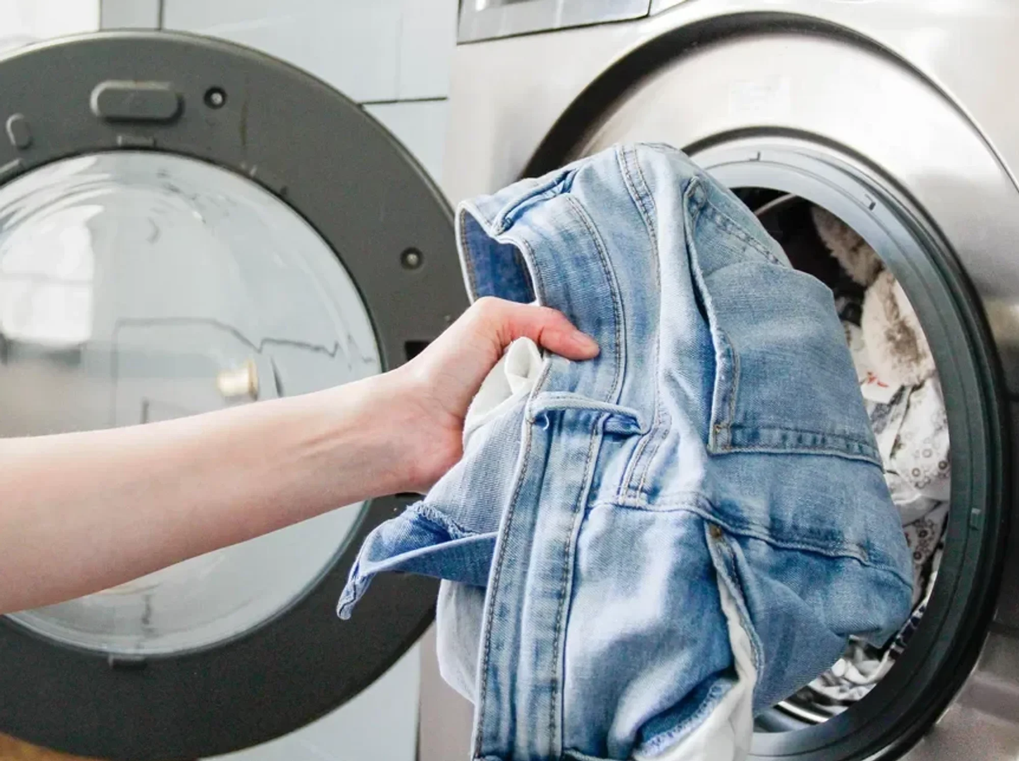 Person taking jeans out of tumble dryer
