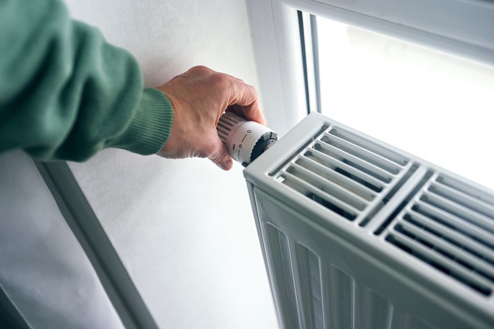 Person turning up radiator