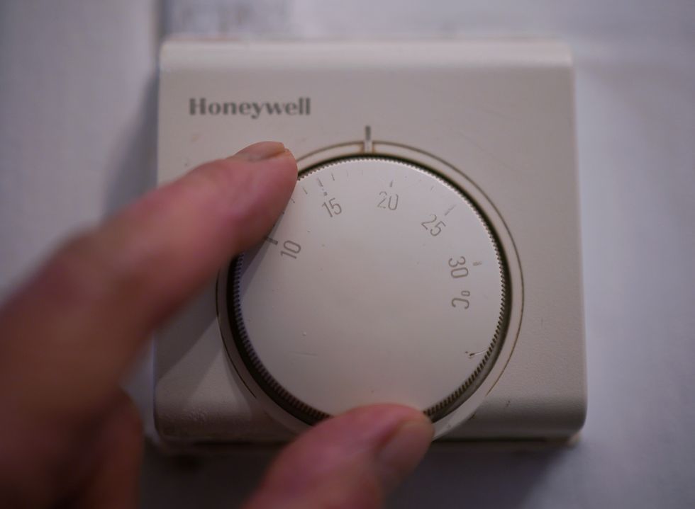 Person turns up dial on thermostat