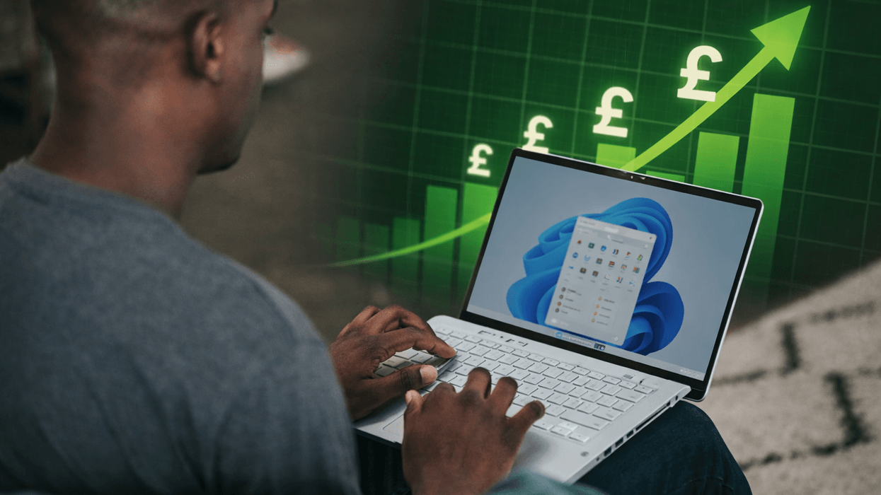 Person typing on Windows 11 laptop with price chart in background