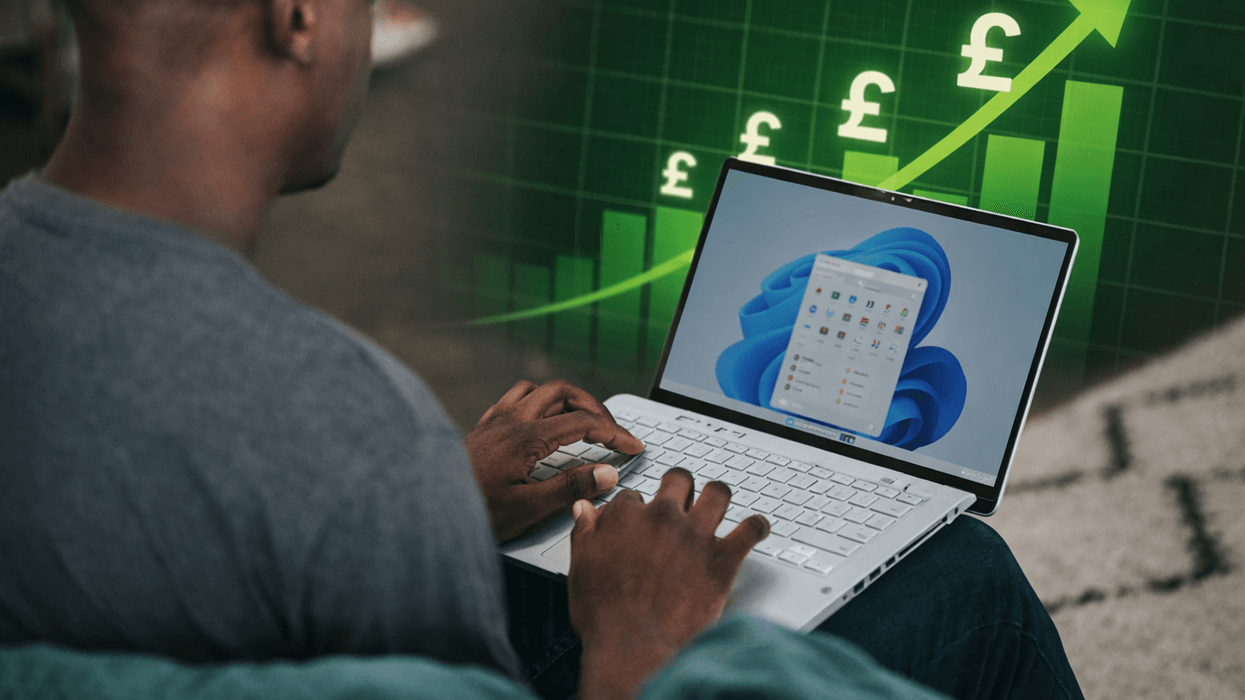 Person typing on Windows 11 laptop with price chart in background