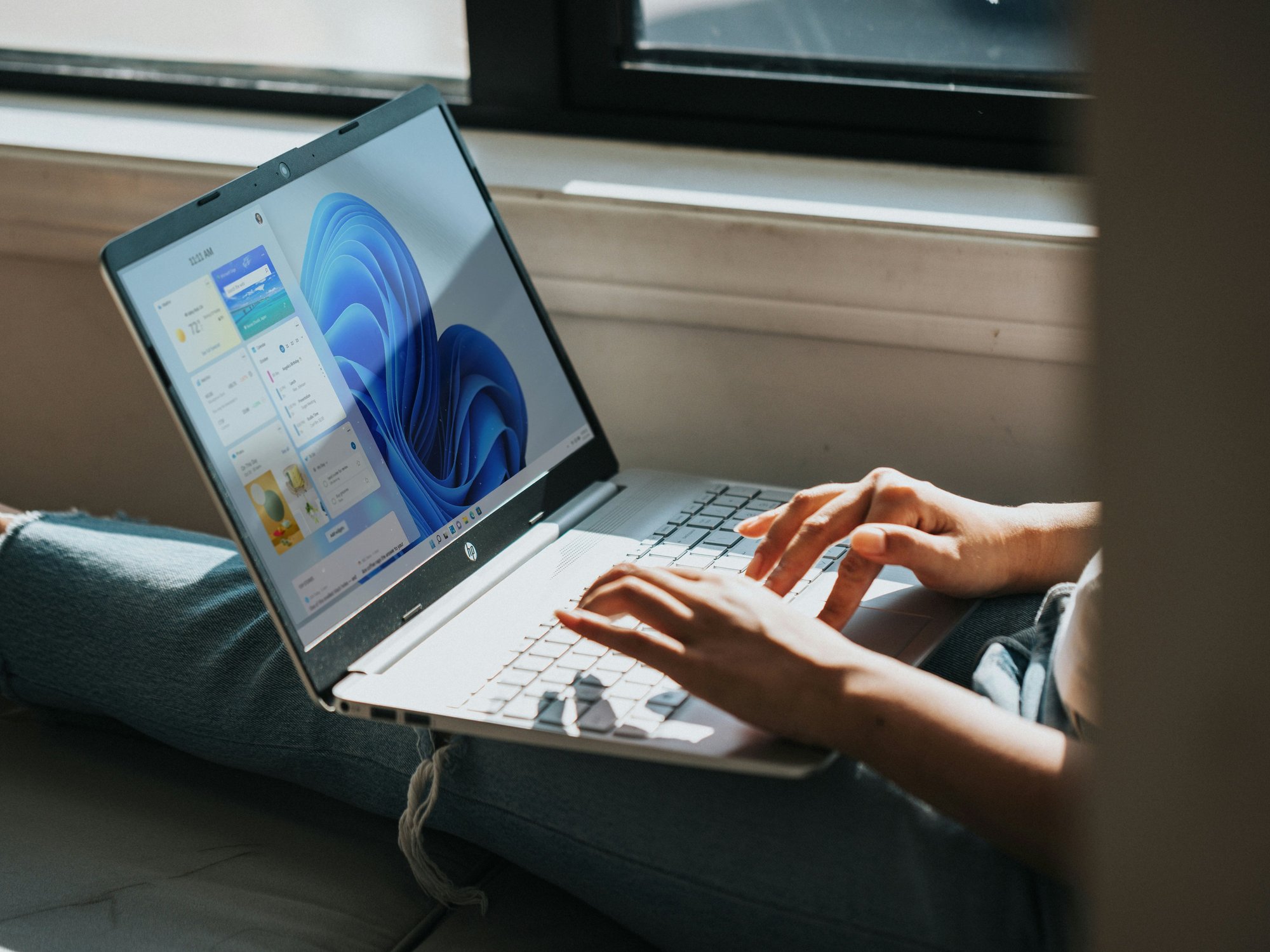 Person typing on Windows 11 laptop